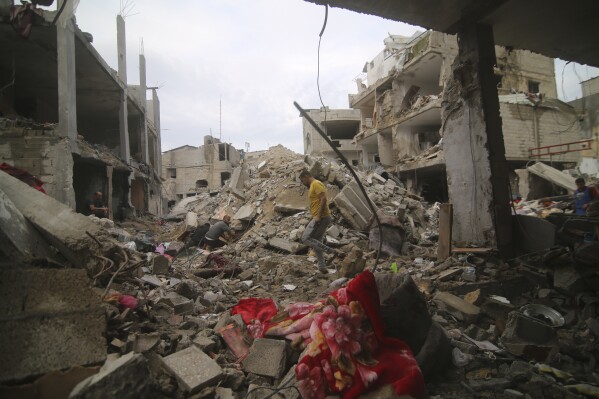 Người Palestine kiểm tra đống đổ nát của gia đình Abu Helal ở trại tị nạn Rafah, Dải Gaza, Thứ Hai, ngày 9 tháng 10 năm 2023. Cuộc tấn công đã giết chết hàng chục người. (Ảnh AP / Hatem Ali)