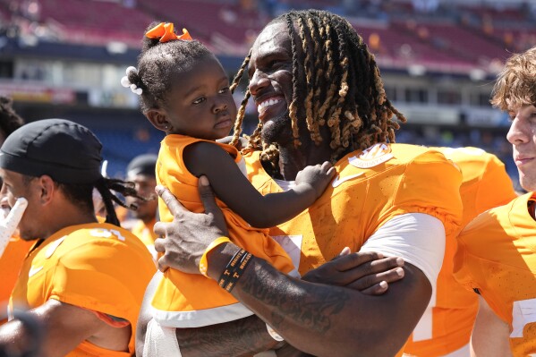 Tennessee quarterback Joe Milton III, right, celebrates the team's 49-13 win against Virginia with his one-year-old sister Journey after an NCAA college football game Saturday, Sept. 2, 2023, in Nashville, Tenn. (AP Photo/George Walker IV)