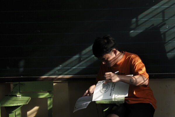 A man prepares to cast his ballot at a polling station in Quezon City, Philippines, Monday, May 12, 2025. (AP Photo/Basilio Sepe)