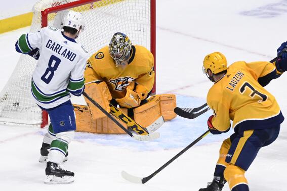 Vancouver Canucks right wing Conor Garland (8) scores against Nashville Predators goaltender Juuse Saros (74) during the third period of an NHL hockey game Tuesday, Feb. 21, 2023, in Nashville, Tenn. The Predators won 5-4 in a shootout. (AP Photo/Mark Zaleski)