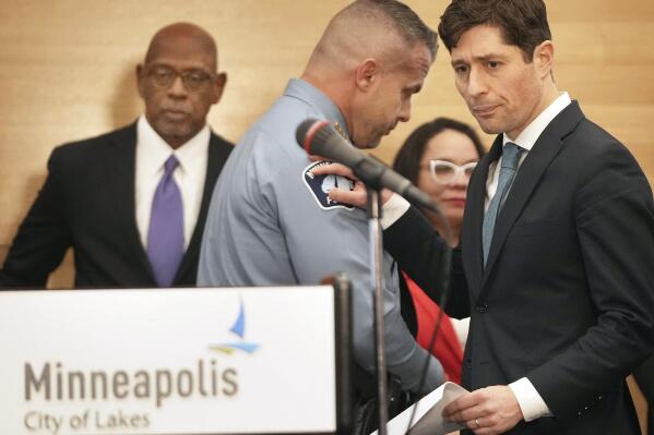 Minneapolis Mayor Jacob Frey, right, pats the shoulder of Minneapolis Police Chief Brian O'Hara after O' Hara spoke during a press conference announcing approval of a sweeping plan to reform policing that aims to reverse years of systemic racial bias Friday, March 31, 2023 at the Minneapolis Public Service Building in Minneapolis. The Minneapolis City Council on Friday approved an agreement with the state to revamp policing, nearly three years after a city officer killed George Floyd. (David Joles/Star Tribune via AP)
