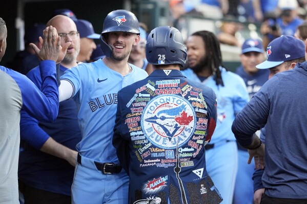 Toronto Blue Jays' Cavan Biggio is greeted in the dugout next to Daulton Varsho after Varsho's two-run home run during the seventh inning of a baseball game against the Detroit Tigers, Thursday, May 23, 2024, in Detroit. (AP Photo/Carlos Osorio)