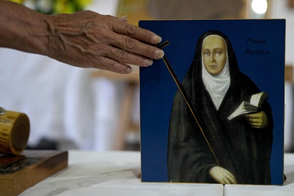 Ένας πιστός αγγίζει έναν πίνακα που απεικονίζει τη María Antonia de Paz y Figueroa, περισσότερο γνωστή με το όνομα Κέτσουα 