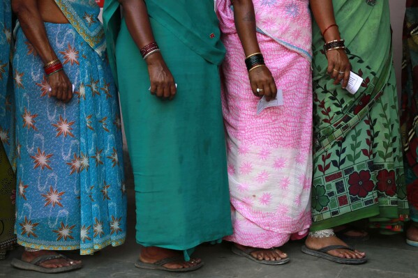 FILE- Indian women stand in a queue to cast their votes in Rajnandgaon, in the central Indian state of Chhattisgarh, April 17, 2014. With a population of over 1.4 billion people and close to 970 million voters, India’s 2024 general election will pit Prime Minister Narendra Modi, an avowed Hindu nationalist, against a broad alliance of opposition parties that are struggling to play catch up. (AP Photo/Rafiq Maqbool, File)