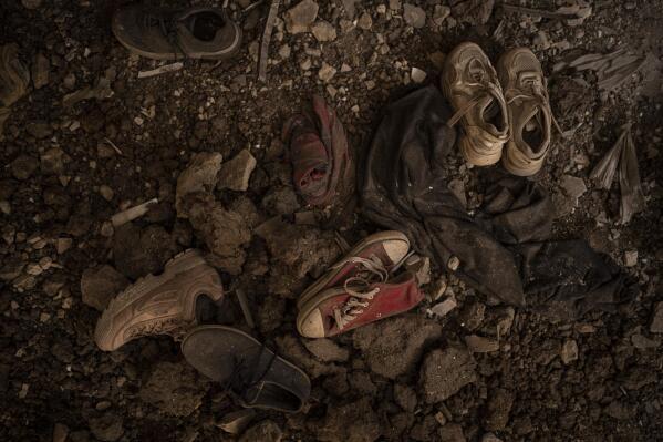 Children's shoes are abandoned amid the rubble inside the badly damaged school No. 62, placed on the road where the first clashes between the Russian and Ukrainian forces took place a year ago, in Kharkiv, Ukraine, Friday, Feb. 24, 2023. Ukraine's leader pledged Friday to push for victory in 2023 as he and other Ukrainians marked the somber anniversary of the Russian invasion that upended their lives and Europe's security. (AP Photo/Vadim Ghirda)
