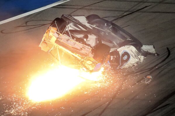 El auto de Ryan Newman se desliza por la pista envuelto en llamas tras una colisión y volcadura en la recta final de las 500 Millas de Daytona, el lunes 17 de febrero de 2020 (AP Foto/David Graham)
