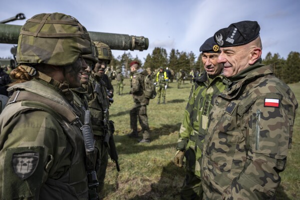 FILE - Poland's Chief of the General Staff, Gen. Rajmund Andrzejczak, right, talks to conscripted tank crews during the Aurora 23 military exercise at the Rinkaby firing range outside Kristianstad, Sweden, Saturday, May 6, 2023. Two top commanders of the armed forces, the Chief of the General Staff, Gen. Rajmund Andrzejczak, and operational commander Gen. Tomasz Piotrowski have tendered their resignations. (Johan Nilsson/TT News Agency via AP, File)