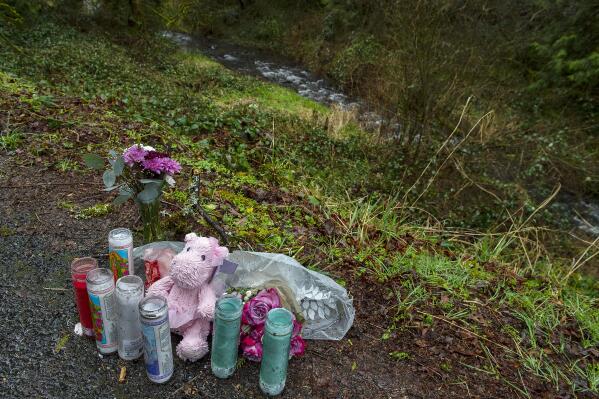 A small memorial overlooks Gibbons Creek as people honor the memory of Meshay "Karmen" Melendez, 27, and her daughter, Layla Stewart, 7, along Wooding Road in Washougal, Wash., Thursday, May 23, 2023. Authorities found two bodies believed to be theirs in the brushy area on Wednesday. (Amanda Cowan/The Columbian via AP)