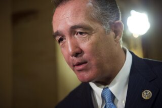 FILE - In this March 24, 2017, file photo, Rep. Trent Franks, R-Ariz. speaks with a reporter on Capitol Hill in Washington. Franks says he is resigning Jan. 31 amid a House Ethics Committee investigation of possible sexual harassment. Franks says in a statement that he never physically intimidated, coerced or attempted to have any sexual contact with any member of his congressional staff. Instead, he says, the dispute resulted from a discussion of surrogacy. Franks and his wife have 3-year-old twins who were conceived through surrogacy. (AP Photo/Cliff Owen, File)