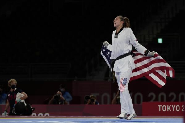 United States's Anastasija Zolotic celebrates as she holds her country national flag after winning a gold medal for the taekwondo women's 57kg match at the 2020 Summer Olympics, Sunday, July 25, 2021, in Tokyo, Japan. (AP Photo/Themba Hadebe)