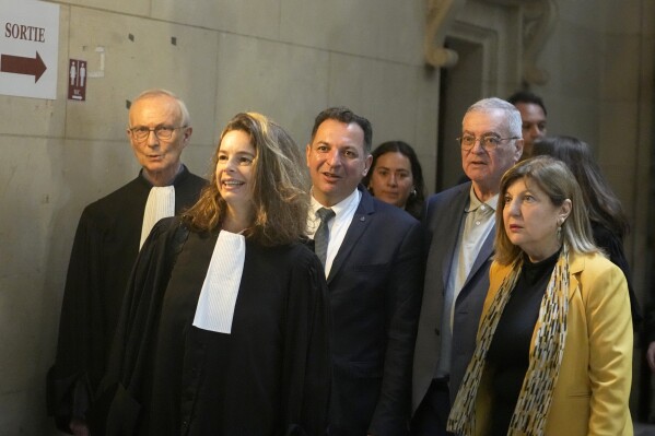 Lawyer Clemence Bectarte, second left, arrives at the court room with Syrian lawyer Mazen Darwish, center, Obeida Dabbagh,brother of Mazen Dabbagh, second right and his wife Hanane, Tuesday, May 21, 2024 at the courtroom in Paris. A Paris court will this week seek to determine whether Syrian intelligence officials — the most senior to go on trial in a European court over crimes allegedly committed during the country's civil war — were responsible for the 2013 disappearance and deaths of Patrick and his father Mazen. (AP Photo/Michel Euler)