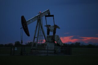 FILE In this April 21, 2020 file photo, a pumpjack is pictured as the sun sets in Oklahoma City.  Google says it won’t build custom artificial intelligence tools for speeding up oil and gas extraction, taking an environmental stance that distinguishes it from cloud computing rivals Microsoft and Amazon.  The announcement followed a Greenpeace report on Tuesday, May 19,  that documents how the three tech giants are using AI and computing power to help oil companies find and access oil and gas deposits in the U.S. and around the world. (AP Photo/Sue Ogrocki File)