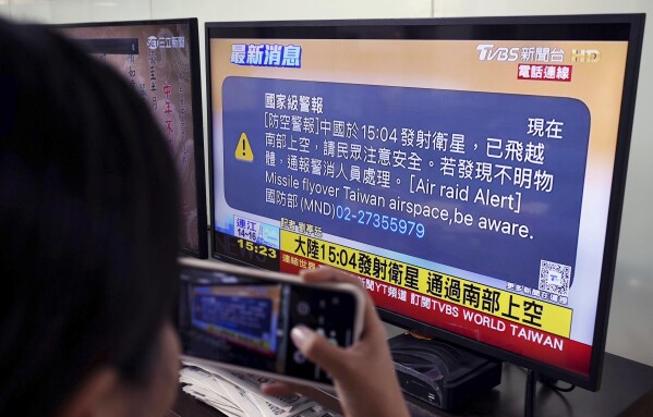 A TV monitor in Taipei, Taiwan flashes news that a satellite launched from China passed over southern Taiwan, Tuesday, Jan. 9, 2024. Taiwan’s defense ministry issued an alert Tuesday saying China has launched a satellite and urging caution days before the island's elections. (Kyodo News via AP)