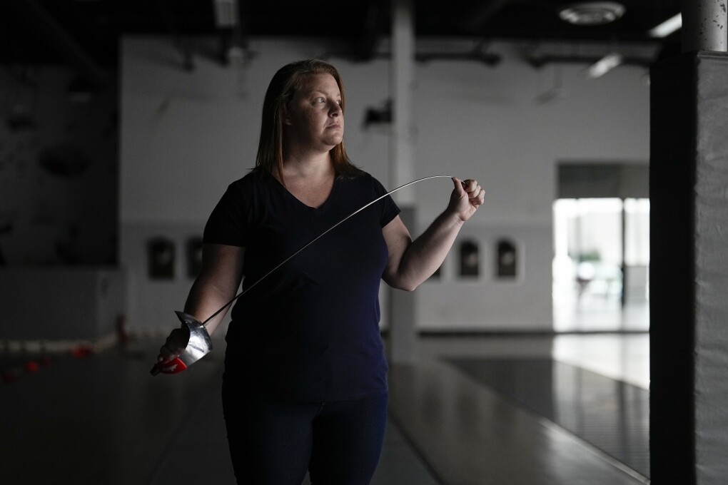 Fencer Kirsten Hawkes poses for a portrait at a fencing studio Tuesday, Sept. 12, 2023, in San Diego. The former elite fencer feels let down by the U.S. Center for SafeSport after filing a complaint to the agency formed six years ago to combat sexual misconduct in Olympic sports. Hawkes’ former coach, who she accused of forcing an unwanted kiss on her and other abuse, never went on a list of the agency's disciplinary database — not after SafeSport handed him a three-month probation, nor after the probation was overturned by an arbitrator. (AP Photo/Gregory Bull)