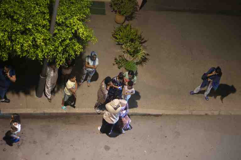 People take shelter and check for news on their mobile phones after an earthquake in Rabat, Morocco, late Friday, Sept. 8, 2023. (AP Photo/Mosa'ab Elshamy)