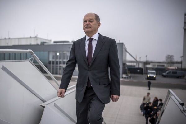 German Chancellor Olaf Scholz boards a plane at the military section of Berlin Brandenburg Airport to fly to the USA, in Schönefeld, Germany, Thursday, Feb. 8, 2024. Scholz pushed for further U.S. and European aid for Ukraine as he set off Thursday for a visit to Washington, declaring that it's time to send Russian President Vladimir Putin a “clear signal” that the West won't let up on supporting Kyiv. Scholz is due to meet members of the U.S. Congress on Thursday and President Joe Biden on Friday. (Michael Kappeler/dpa via AP)
