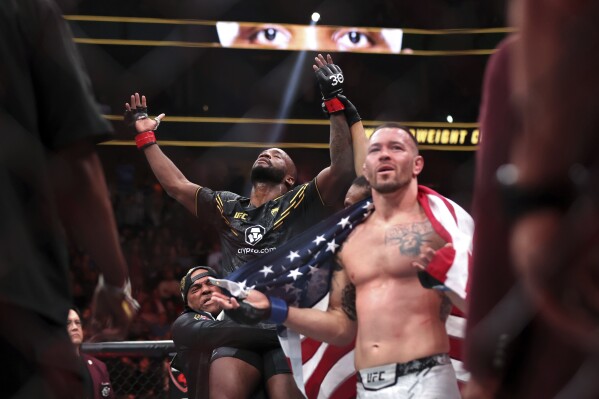 UFC welterweight champion Leon Edwards, left, celebrates after being declared the winner by unanimous decision over Colby Covington, right, during the UFC 296 mixed martial arts event Saturday, Dec. 16, 2023, in Las Vegas. (Steve Marcus/Las Vegas Sun via AP)