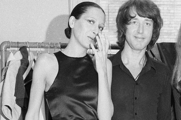 FILE - Elsa Peretti, left, poses with designer Halston after a fashion show in New York on June 15, 1970.  Famed jewelry designer Elsa Peretti, a formal Halston model turned Tiffany & Co. legend, is dead at age 80. According to a family statement, Peretti died Thursday night in her sleep at home in a small village outside Barcelona.  (AP Photo/Marty Lederhandler, File)
