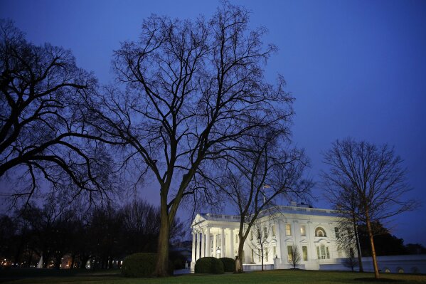 In this Feb. 6, 2020 photo, dusk settles over the White House in Washington. Confronted with trillion-dollar-plus deficits, President Donald Trump is offering a budget plan on Monday that’s offering a rehash of previously rejected spending cuts, while keeping a promise to leave Social Security and Medicare benefits untouched. (AP Photo/Patrick Semansky)