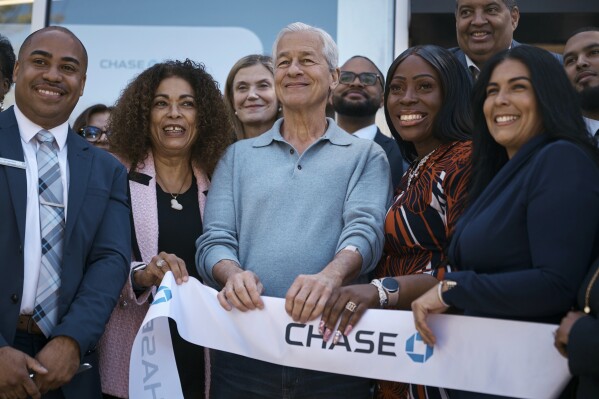 Jamie Dimon, CEO and chairman of JPMorgan Chase, center, attends the ribbon-cutting ceremony during the community branch opening in the Bronx borough of New York, on Friday, April 26, 2024. Dimon says he’s hopeful the Federal Reserve can bring down inflation without causing a recession but wouldn’t rule out more troubling possibilities, such as stagflation. (AP Photo/Andres Kudacki)