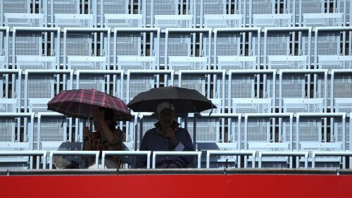 DATEI – Zwei Spieler halten einen Regenschirm während des WTA-Halbfinal-Tennisspiels zwischen Belinda Bencic aus der Schweiz und Maria Zakari aus Griechenland am 18. Juni 2022 in Berlin, Deutschland.  Am Montag, 26. Juni 2023, kündigte die Bundesregierung an, einen Wettbewerb zu starten.  Eine Kampagne, die den lokalen Behörden dabei helfen soll, zu verhindern, dass schutzbedürftige Menschen bei häufigeren und intensiveren Hitzewellen aufgrund des Klimawandels sterben.  (AP Photo/Michael Sohn, Datei)