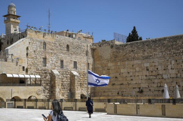 Israel's national flag is lowered to half-mast as the country observes a day of mourning after the death of 45 ultra-Orthodox Jews in a stampede at a religious festival at Mt. Meron last Friday, at the plaza in front of the Western Wall, Judaism's holiest prayer site, in Jerusalem's Old City, Sunday, May 2, 2021. Officials came under growing scrutiny Sunday for ignoring warnings about safety lapses at one of Israel’s most visited holy sites, as the country mourned 45 ultra-Orthodox Jews killed in a stampede at a festival there. (AP Photo/Mahmoud Illean)