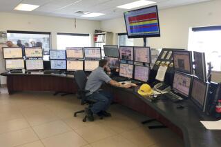 FILE - This July 16, 2015 file photo shows employee Michael Kurian at Idaho Power Company's Langley Gulch Power Plant in New Plymouth, Idaho. Idaho Power has submitted a 20-year plan to state regulators that phases out coal-fired power plants by 2028 as part of an effort to provide only clean energy by 2045. The public utility in a news release, Tuesday, Jan. 4, 2022, said it submitted its Integrated Resources Plan to the Idaho Public Utilities Commission. (AP Photo/Keith Ridler, File)