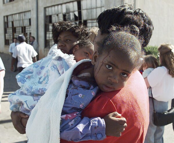 A woman comforts an injured child following an explosion at the Alfred P. Murrah Federal Building in Oklahoma City on April 19, 1995. (AP Photo/David Longstreath, File)