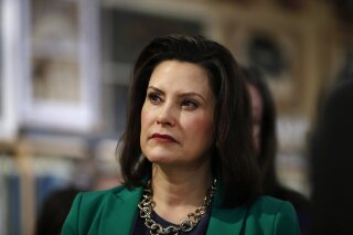 FILE - In this March 18, 2019, file photo, Michigan Gov. Gretchen Whitmer listens to Democratic presidential candidate Sen. Kirsten Gillibrand, D-N.Y., in Clawson, Mich. Whitmer is moving to make Michigan the first state to ban flavored e-cigarettes. The Democrat announced Wednesday, Sept. 4 that she ordered the state health department to issue emergency rules. They will prohibit the sale and misleading marketing of flavored nicotine vaping products.  (AP Photo/Paul Sancya, File)