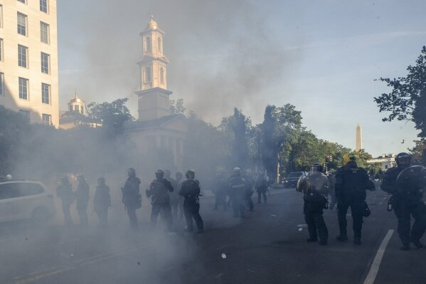 Tear gas floats in the air as a line of police move demonstrators away from St. John's Church across Lafayette Park from the White House, as they gather to protest the death of George Floyd, Monday, June 1, 2020, in Washington. Floyd died after being restrained by Minneapolis police officers. (AP Photo/Alex Brandon)