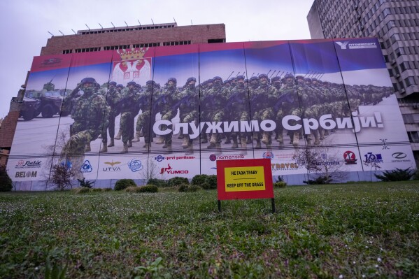 A huge billboard that shows Serbian soldiers reading: "We serve Serbia!" displayed on the former Serbian army headquarters, destroyed during NATO's bombing campaign, in Belgrade, Serbia, Sunday, March 24, 2024. Serbia marks the 25th anniversary of beginning of the NATO air-campaign in 1999, on Sunday. (AP Photo/Darko Vojinovic)