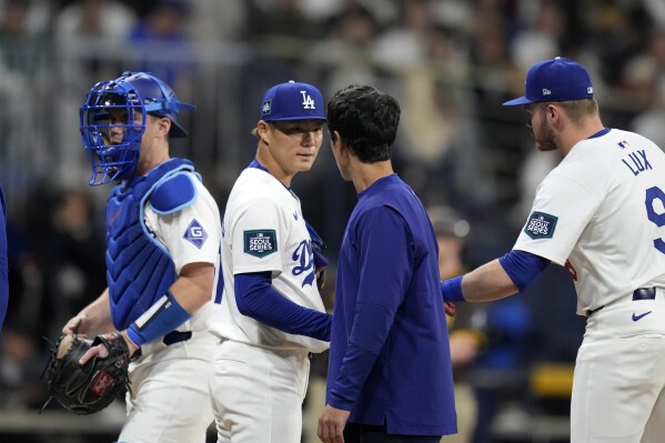 Los Angeles Dodgers starting pitcher Yoshinobu Yamamoto, second from left, speaks with interpreter Will Ireton, second from right, as catcher Will Smith, left, and second baseman Gavin Lux during the first inning of a baseball game at the Gocheok Sky Dome in Seoul, South Korea Thursday, March 21, 2024, in Seoul, South Korea. (AP Photo/Lee Jin-man)