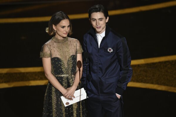 Natalie Portman, left, and Timothee Chalamet present the award for best adapted screenplay at the Oscars on Sunday, Feb. 9, 2020, at the Dolby Theatre in Los Angeles. (AP Photo/Chris Pizzello)