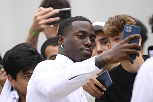 US soccer player Timothy Weah, front, takes a selfie as he arrives for fitness tests at the Italian soccer club Juventus F.C. in Turin, Italy, Thursday, June 29, 2023. (Fabio Ferrari/LaPresse via AP)