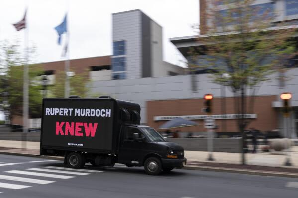 A protest vehicle drives past the justice center in Wilmington, Del., Monday, April 17, 2023, where the Dominion Voting Systems' defamation lawsuit against Fox News is set to take place. The Delaware judge overseeing the voting machine company's $1.6 billion lawsuit has announced a delay in the start of the trial until Tuesday, giving no explanation in announcing the recess. (AP Photo/Matt Rourke)