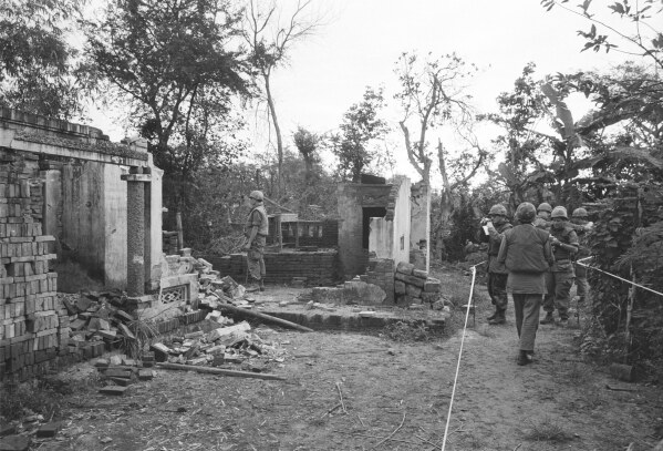 American soldiers look over the remains of a home in My Lai, South Vietnam in this Jan. 8, 1970 file photo. The GIs are in a safe area marked off with white tape, having been swept for booby-traps that have already wounded five soldiers since the investigation of the killing of unarmed civilians by members of the U.S. Army; what would come to be called The My Lai Massacre, began. (AP Photo/File)