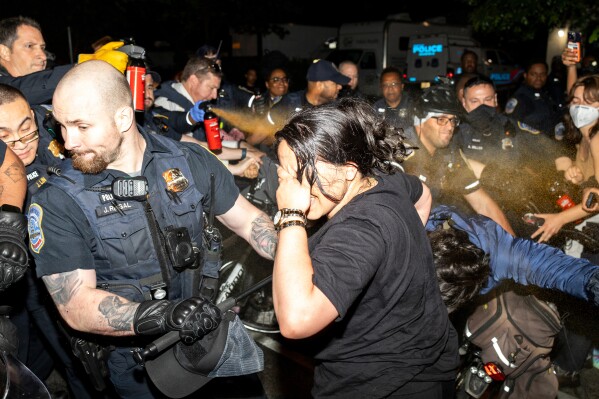 Officers of the Metropolitan Police Department pepper spray demonstrators at George Washington University in Washington, early Wednesday, May 8, 2024. Police cleared a pro-Palestinian tent encampment at the university and arrested demonstrators early Wednesday, hours after dozens marched to the home of the school’s president. (Sage Russell/GW Hatchet via AP)