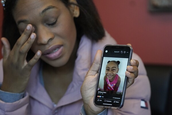 FILE - Brittany Tichenor-Cox holds a photo of her daughter, Isabella 