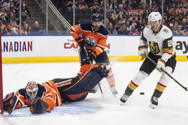 Vegas Golden Knights' Mattias Janmark (26) is stopped by Edmonton Oilers' goalie Mike Smith (41) as Duncan Keith (2) defends during the first period of an NHL hockey game Saturday, April 16, 2022 in Edmonton, Alberta. (Jason Franson/The Canadian Press via AP)