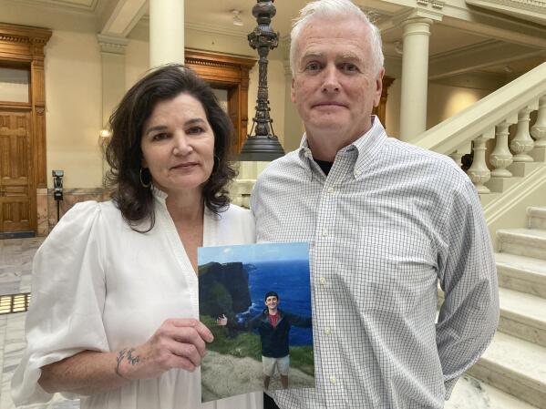 Dana and John Pope pose with a photo of their son Ethan, following a news conference at the Capitol in Atlanta, Thursday, Oct. 27, 2022. Ethan was 23 when he died in December 2021 after using kratom. His parents have filed a wrongful death lawsuit against about a dozen people, companies and organizations connected to the manufacture, marketing and sale of the herbal supplement. (AP Photo/Kate Brumback)