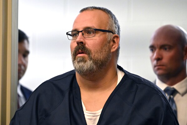 CORRECTS TO HEARING, INSTEAD OF ARRAIGNMENT - Former Letcher County Ky. Sheriff Shawn "Mickey" Stines is led into the courtroom for a hearing at the Morgan County Courthouse in West Liberty, Ky., Tuesday, Oct. 1, 2024. Stines is accused of killing District Judge Kevin Mullins. (AP Photo/Timothy D. Easley)