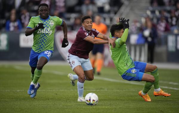 Sounders centerback, Arreaga, being pulled down by a Rapids player.