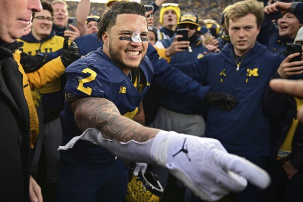 Michigan running back Blake Corum celebrates with fans after Michigan defeated Ohio State 30-24 in an NCAA college football game, Saturday, Nov. 25, 2023, in Ann Arbor, Mich. (AP Photo/David Dermer)