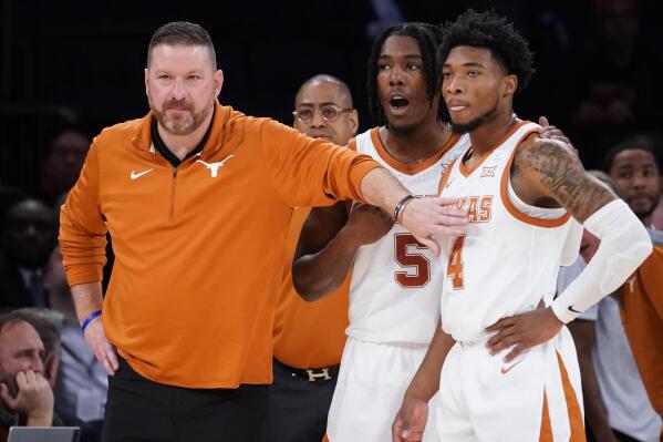 FILE - Texas' head coach Chris Beard, left, meets with Tyrese Hunter (4) and Marcus Carr (5) at the bench during the first half of the team's NCAA college basketball game against Illinois in the Jimmy V Classic, Tuesday, Dec. 6, 2022, in New York. Texas fired basketball coach Chris Beard on Thursday, Jan. 5, 2023, while he faces a felony domestic family violence charge stemming from a Dec. 12 incident involving his fiancée. (AP Photo/John Minchillo, File)