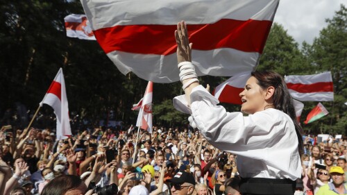 FILE - Sviatlana Tsikhanouskaya, candidate for the presidential elections greets people waving old Belarus flags during a meeting to show her support in Brest, 326 km (203,7 miles) southwest of Minsk, Belarus on Sunday, Aug. 2, 2020. Belarusian opposition leader Sviatlana Tsikhanouskaya says she received an anonymous note alleging that her imprisoned husband, also an opposition figure, died behind bars. Siarhei Tsikhanouski was arrested in 2020 after announcing plans to run against Belarus' authoritarian leader, Alexander Lukashenko, in presidential elections that year. Tsikhanouskaya ran in his stead after the arrest. (AP Photo, File)