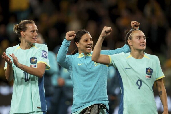 Australia's Emily Van Egmond, Sam Kerr and Caitlin Foord, from left, celebrate at the end of the Women's World Cup Group B soccer match between Australia and Canada in Melbourne, Australia, Monday, July 31, 2023. Australia won 4-0. (AP Photo/Hamish Blair)