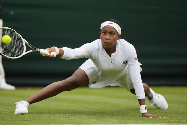 Coco Gauff of the US slips on the grass as she plays a return to Britain's Francesca Jones during the women's singles first round match on day two of the Wimbledon Tennis Championships in London, Tuesday June 29, 2021. (AP Photo/Alastair Grant)