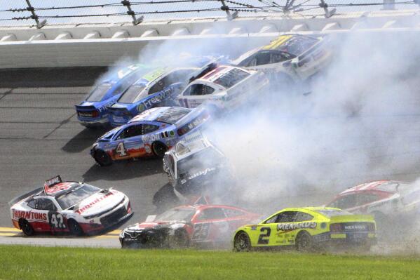 Chris Buescher (17), Daniel Suarez (99), Denny Hamlin (11), Justin Haley (31), Kevin Harvick (4), Ty Dillon (42), Aric Almirola (10) and others are involved in a multi-car accident between turns 1 and 2 during a NASCAR Cup Series auto race at Daytona International Speedway, Sunday, Aug. 28, 2022, in Daytona Beach, Fla. (AP Photo/Dow Graham)