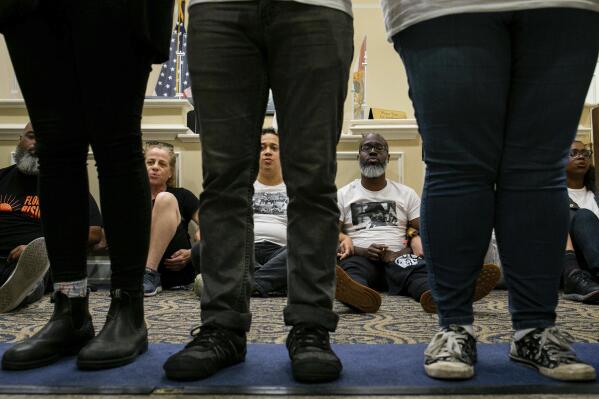 Dozens of activists stage a sit-in outside Florida Gov. Ron DeSantis' office and force people to step over them to reach DeSantis' office as they speak out against the governor and his policies, Wednesday, May 3, 2023, in Tallahassee, Fla. Florida Republicans on Wednesday approved bills to ban diversity programs in colleges and prevent students and teachers from being required to use pronouns that don't correspond to someone's sex, building on top priorities of the Republican governor. (Alicia Devine/Tallahassee Democrat via AP)