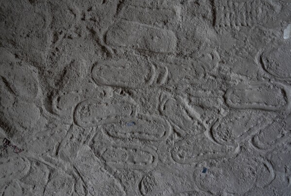 Footprints are visible at Chanaute Market, Melamchi, northeast from Kathmandu, Nepal, Sunday, Sept. 15, 2024, on the sand inside a house damaged by floods in 2021. (AP Photo/Niranjan Shrestha)